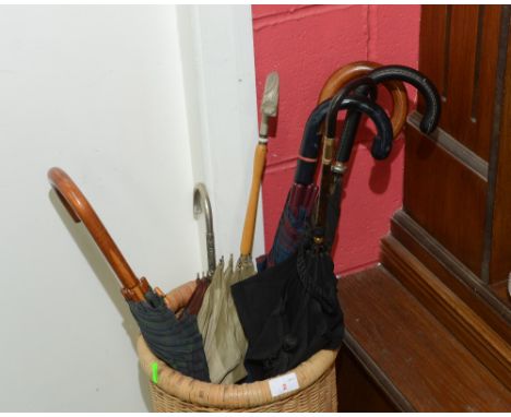 A wicker stick stand containing a quantity of early 20th Century parasols and umbrellas