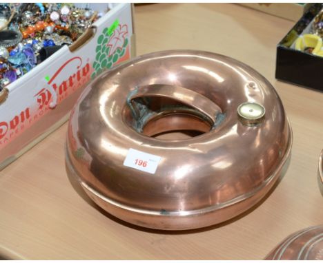 A vintage copper doughnut form hot water bottle