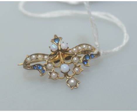 An attractive opal and seed pearl brooch in a scrolling leaf and flower setting