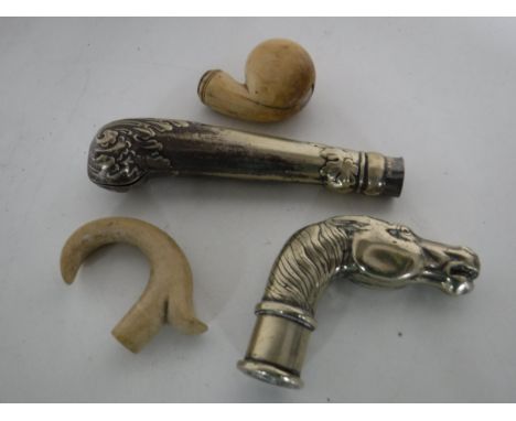 Four antique walking stick heads including a Victorian ivory example with silver inlay, two plated and one carved horn.