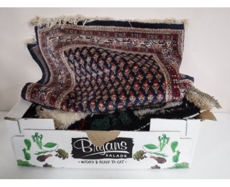 A box of prayer mats, woollen rugs and a tapestry on board 