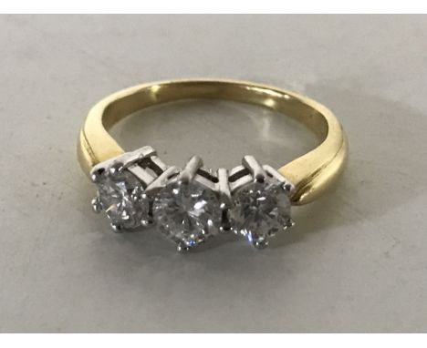 An 18ct gold three stone diamond ring, size K/L, approximately 1ct