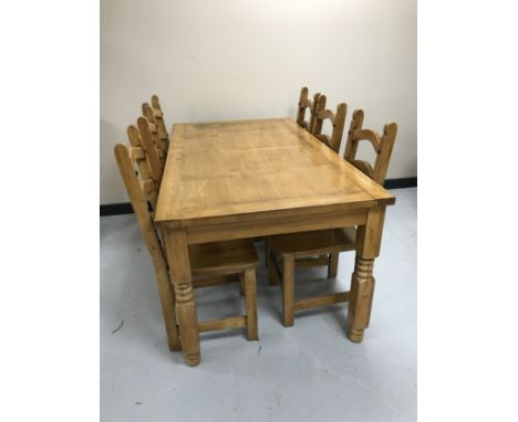 A pine farmhouse style kitchen table and six ladder backed chairs 