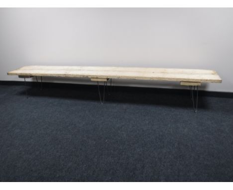 A reclaimed wood 8 foot bench on metal legs 
