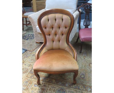 LIGHT OAK CROWN BACK UPHOLSTERED NURSING CHAIR ON BALL AND CLAW SUPPORTS.