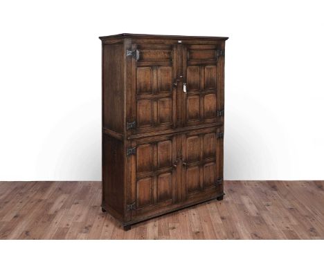 Titchmarsh and Goodwin: a Georgian style oak press cupboard, with moulded cornice above a pair of panel doors opening to reve