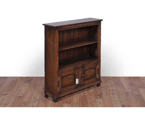 Titchmarsh and Goodwin: a Georgian style oak bookcase, with single shelf above a pair of cupboard doors, 84 x 25 x 96cms high