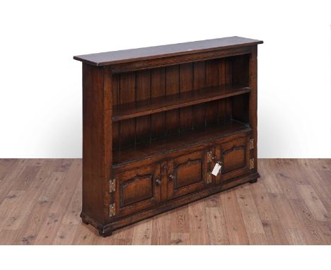 Titchmarsh and Goodwin: a Georgian style oak bookcase with single shelf above three cupboard doors, with N.H Chapman ‘Siesta’