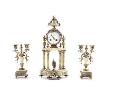 A. D. Mougin: A French onyx and gilt metal clock and garniture, the central pendulum clock with white Arabic dial decorated w