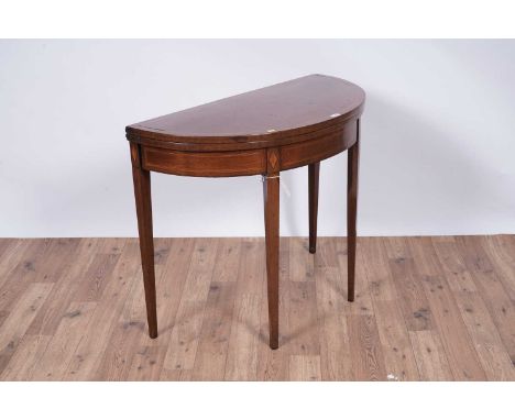 An Edwardian inlaid mahogany card table, with hinged ‘D’ shaped top opening onto gate leg support and revealing a green baize