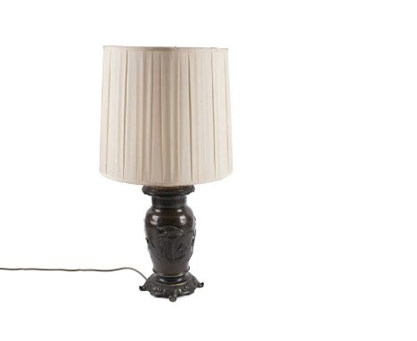 An East Asian bronze table lamp, cast with a panoramic scene of birds, with ornate scrolling borders, 67cms high (including s
