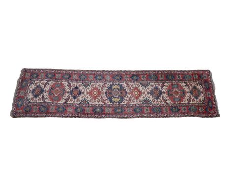 A Caucasian runner, with nine medallions on ivory ground with red border, 80 x 313cms.