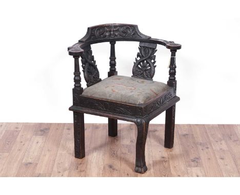 Laidler Robsons &amp; Co, Sunderland: a Victorian carved oak corner chair, with foliate carved top rail and splats with turne