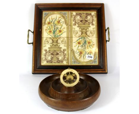 An Edwardian wood and ceramic tile tray with a wooden ships wheel nutcracker, 39 x 39cm.
