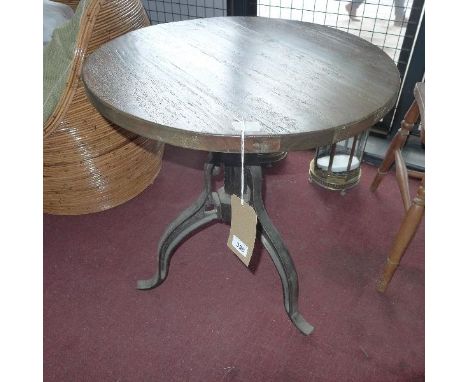 An occasional table, having circular teak top above cast iron tripod base, H.65 W.60cm 