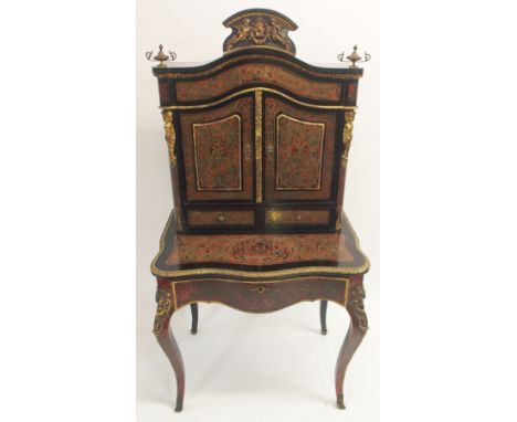 A BOULLE RED TORTOISESHELL, BRASS MOUNTED AND EBONISED CABINET with winged cherubs holding wreaths and joined by a cartouche,