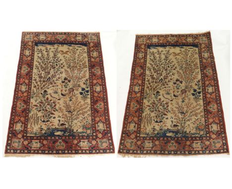 A PAIR OF LIGHT GROUND EASTERN RUGS with a field of blossom trees, ducks, cockerels and other birds with a terracotta border 