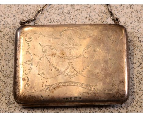 A George V hallmarked silver purse with scrolling engraved foliate decoration, leather interior with silver engine-turned pen