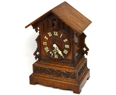 A Gothic-style mahogany cuckoo mantel clock, the dial set with Arabic numerals, height 36.5cm.