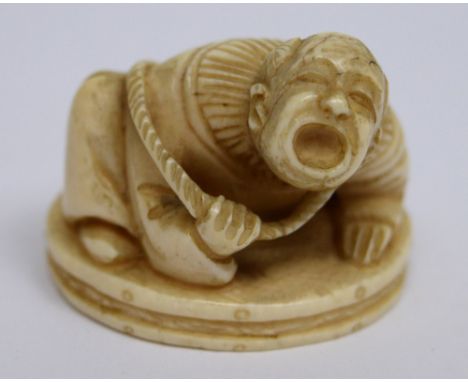 A late 19th century ivory netsuke of a man screaming with rope around his back, height 3cm.