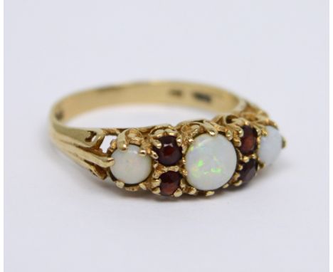 A 9ct yellow gold three opal and garnet set ring, size N, approx 2.2.g.