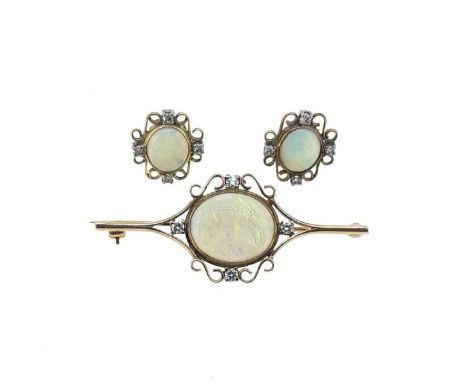 bar brooch with scroll detail, set with an oval cabochon opal, approximately 16 x 13mm, and round brilliant cut diamonds set 