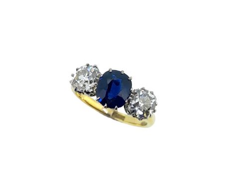 claw set oval faceted sapphire, approximately 7 x 6mm, estimated approximate weight 1.20ct, flanked by two old mine cut diamo