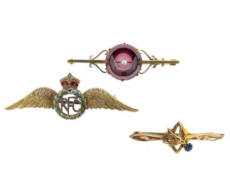the first brooch with a concave cabochon garnet and a central seed pearl, mounted to a flat bar with applied scroll decoratio