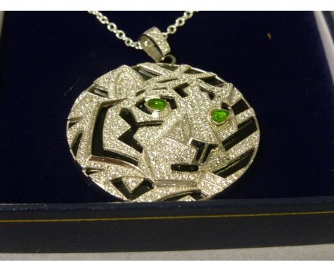 A silver, cz and onyx pendant necklace in the form of a tiger with emerald eyes