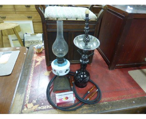 An oil lamp with a metal base, along with a shisha pipe