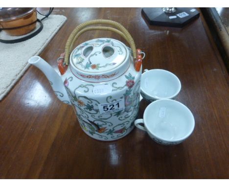 A Chinese teapot and two tea bowls 