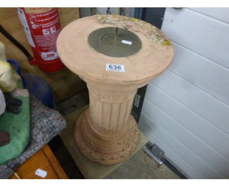 A stone plinth with a brass sundial 