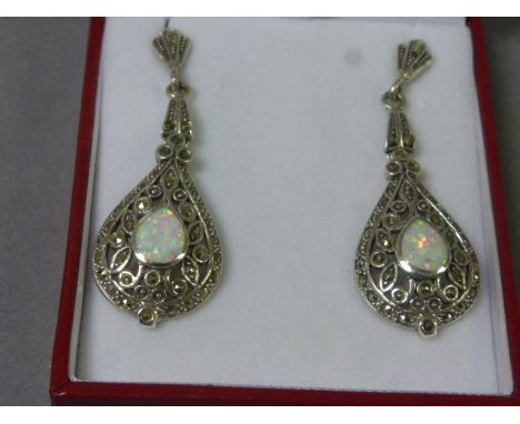 A pair of silver drop earrings in the art deco style set with pear shaped opal panels