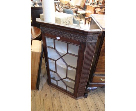 A late 18th Century mahogany astragal glazed corner cupboard with blind fret decoration