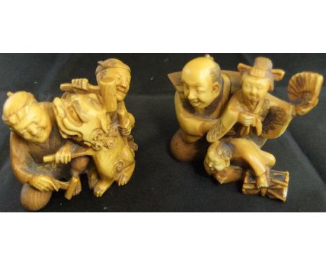 A Japanese carved ivory netsuke as a puppeteer with female puppet holding a fan and boy with drum, signed to base, together w