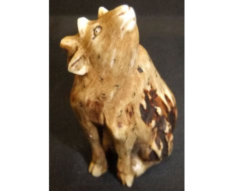 A Japanese carved antler netsuke type figure of a seated stag looking upwards, 4.6cm high