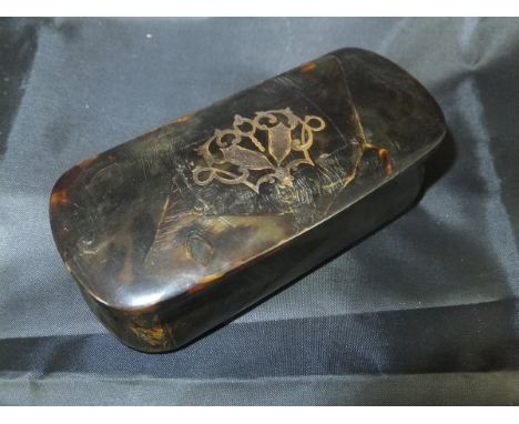 A 19th Century tortoiseshell snuff box of rounded rectangular form with waisted body, the hinged lid set with gold inlay, 10c