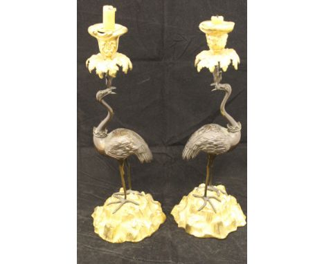 A pair of 19th Century patinated and gilt bronze candlesticks in the Regency manner of Abbott, the foliate cast sockets with 