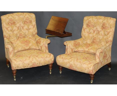 A pair of Howard button back armchairs in pale gold foliate patterned upholstery, raised on turned and ringed front legs to b