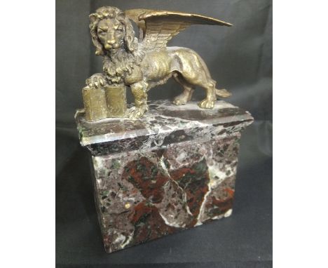 A 19th Century bronze paperweight in the form of the winged lion of St. Mark with a book under it's paw sat on a marble plint