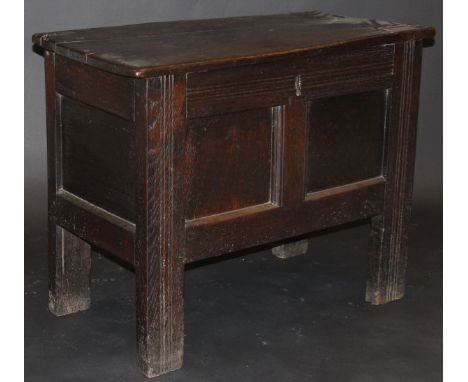 A 17th Century oak coffer, the plank top above a two panel front with moulded decoration, raised on moulded stiles, 91.5 cm w