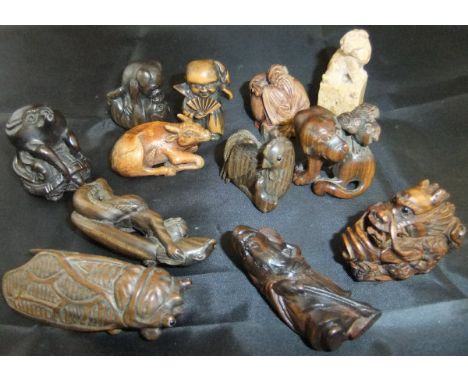A collection of eleven various Japanese carved wooden netsukes and figures, including owl seated upon the back of a dog, two 