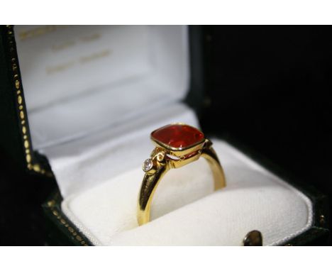 A Boodle & Dunthorne 18ct gold dress ring, the central rounded rectangular cut fire opal approx 3ct flanked by two small diam