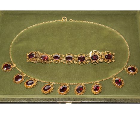 A garnet and filigree yellow metal set necklace 41 cm long, together with a similar scrolling foliate decorated bracelet COND