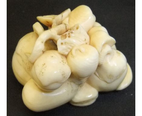 A Meiji period Japanese carved ivory netsuke as a collection of various fruits, to include gourds etc, unsigned, 3.7cm long
