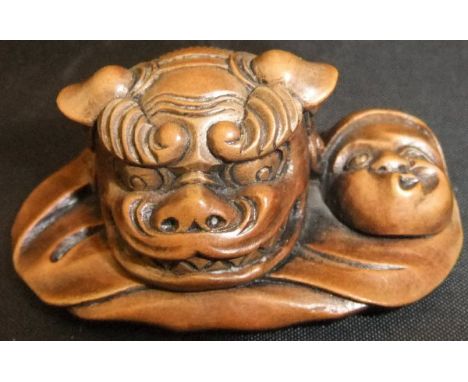 A Japanese carved wood netsuke as Daruma as Hyotoko, with a theatrical lion mask, 5.1cm long