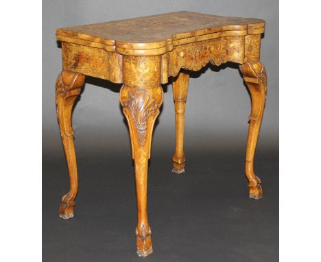 A 19th Century Dutch walnut and inlaid fold-over card table in the early 18th Century manner, the marquetry inlaid top decora