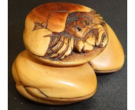 A Japanese carved ivory netsuke as a hermit crab in a seashell, upon two further seashells, set with glass eyes, 3.9cm long C