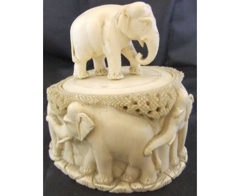 A circa 1900 Indian carved ivory pot and cover, the pot decorated with elephants, the lid with carved elephant finial 13 cm h