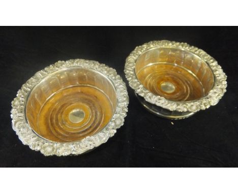 A matched pair of William IV silver bottle coasters with shell and foliate decorated rims above a faceted main body, raised o